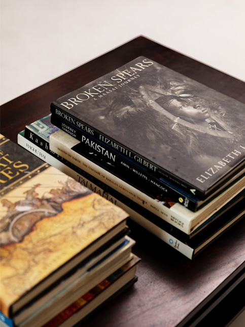 A selection of coffee table books on a dark wooden surface – Beautiful Homes A selection of coffee table books on a dark wooden surface, showcasing titles like "Broken Spears" and "Journey Through Pakistan." – Beautiful Homes