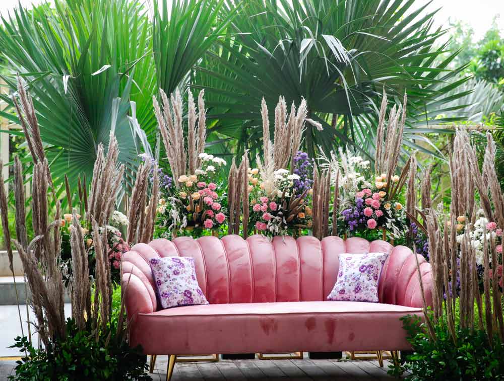 A pink sofa surrounded by flowers A pink sofa surrounded by flowers