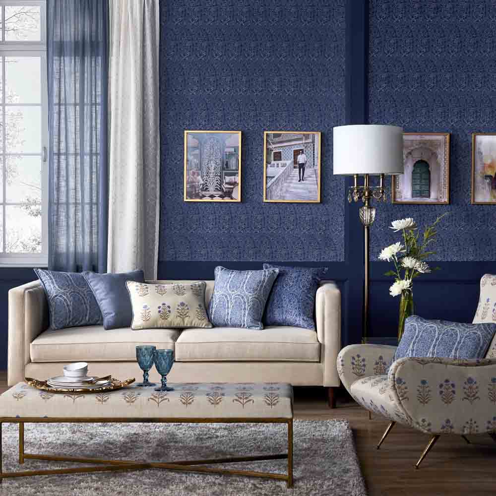 A living room with blue wallpaper and a cream sofa
