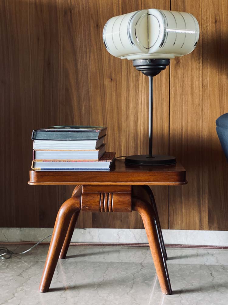 A side table with books and a lamp placed on it