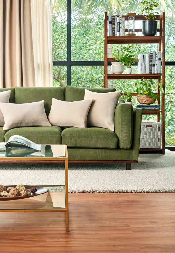 A living room with a green sofa and a white rug