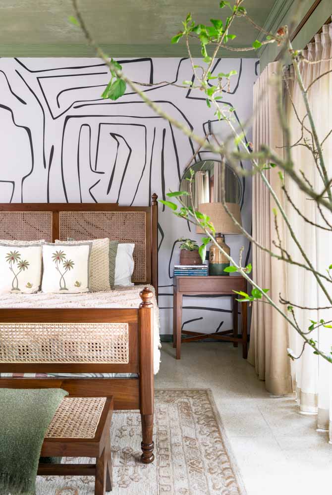 A wooden side table placed next to a bed in a green bedroom