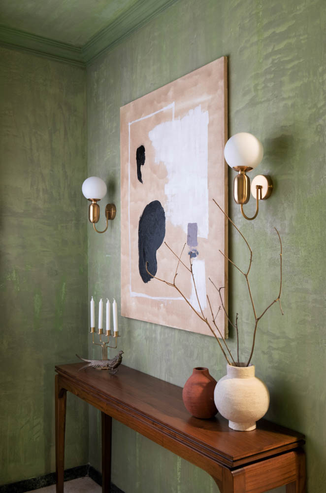 An artwork placed on a wall in a green bedroom