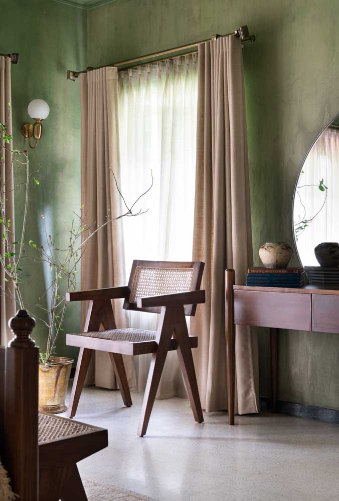 A green bedroom with a Chandigarh chair