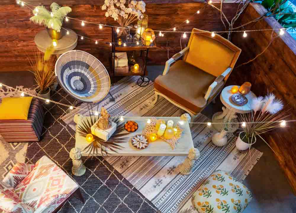 Terrace with a rug, a centre table with candles placed on it, and chairs and and seats placed around the table