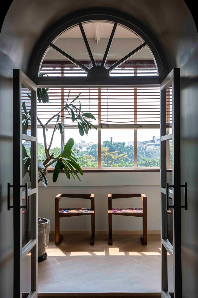 An arch leading to a room with large open windows
