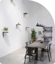 A home interior with dining table, ceiling hanging lights and plants