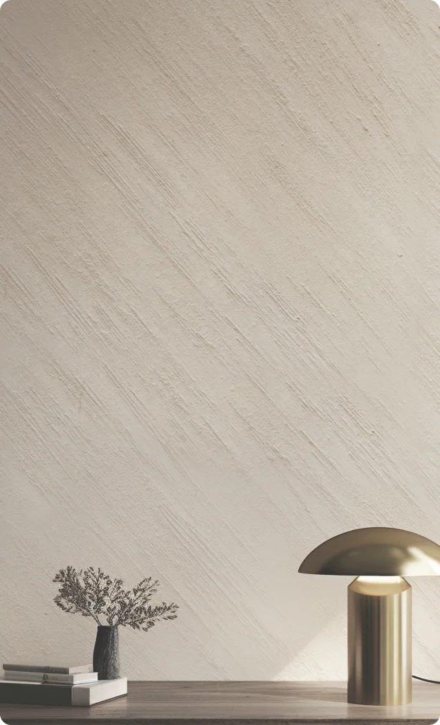 A photo frame and 2 silver candle stands in front of a grey colored textured wall. Asian Paints Royale Play Metallo Fuso collection.