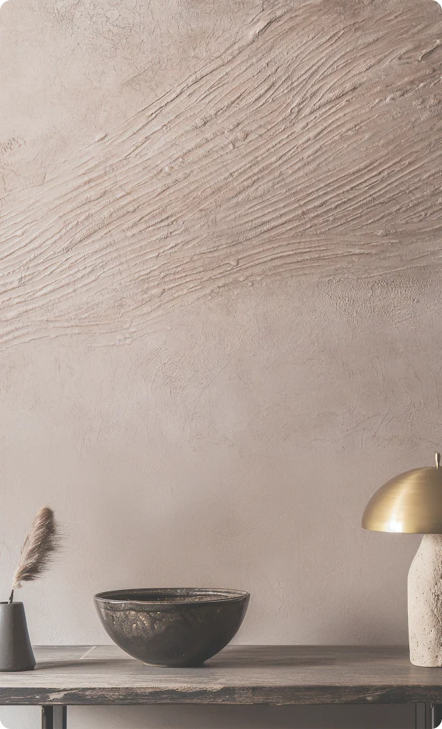 A concrete exposed wall with a contemporary transparent clock and a brown leather sofa against it. Asian Paints Royale Play Archi Concrete Exposed collection.