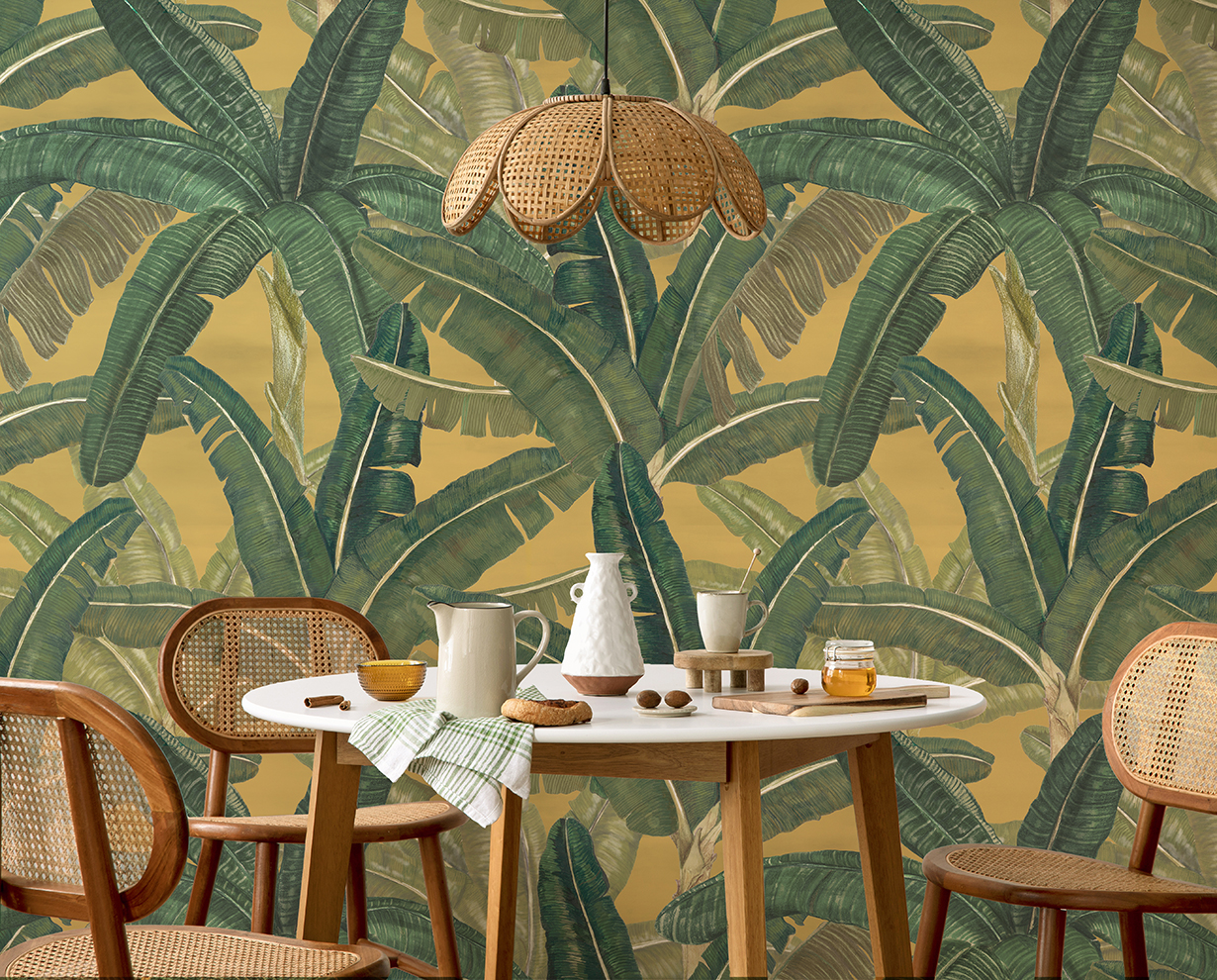 The creative composition of dining room interior with with round table, rattan chair, lamp and kitchen accessories. Green leaf in vase.  Beige wall. Home decor. Template. 