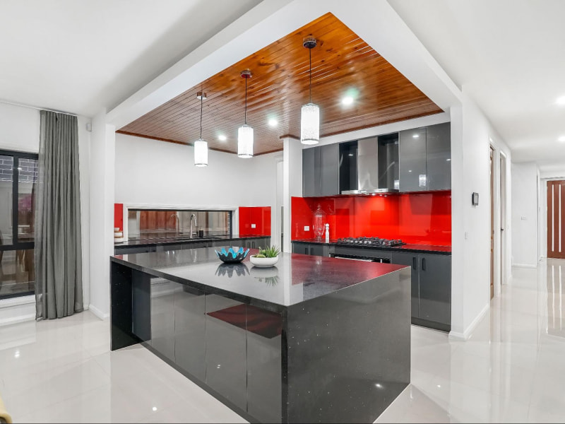 Red wall tile vastu colour for this island kitchen interior design - Beautiful Homes