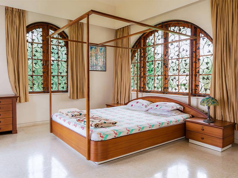 Four-poster bed matching the decorative window grill pattern