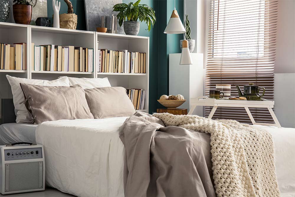 Small bedroom with bookshelves as headboard & décor pieces - Beautiful Homes