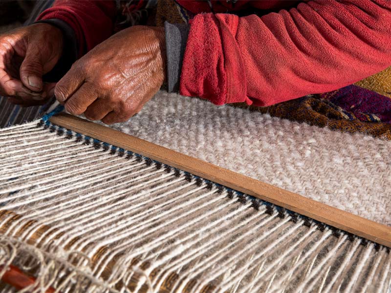 Women weaving raw wool into handwoven products - Beautiful Homes