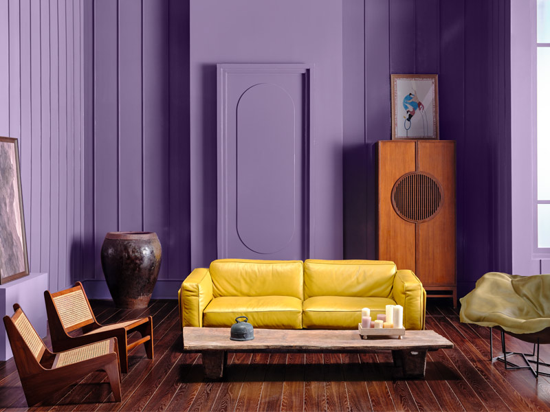 Living room with a yellow sofa, purple walls, and eclectic décor - Beautiful Homes