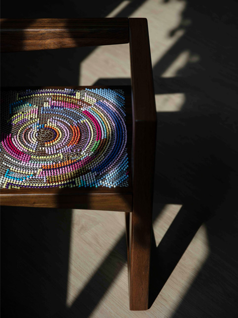 Wooden chair with a colourful beaded pattern on the seat - Beautiful Homes
