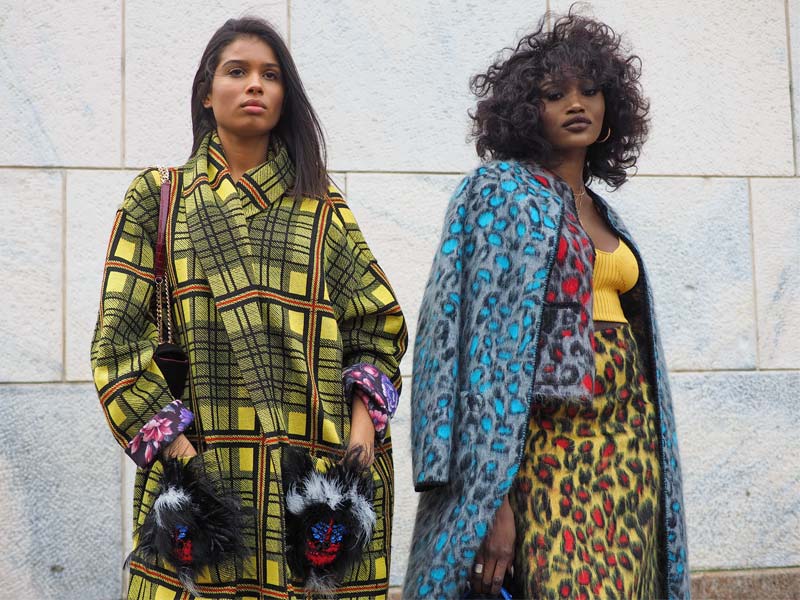 Two individuals wearing vibrant, patterned coats in a stylish outdoor setting – Beautiful Homes