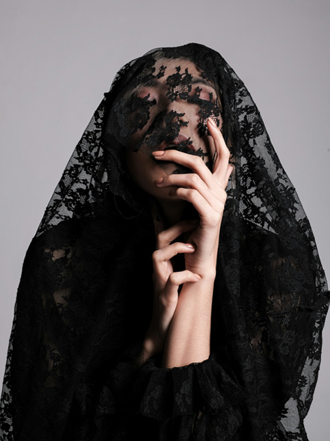 Person draped with a black lace veil covering their face - Beautiful Homes