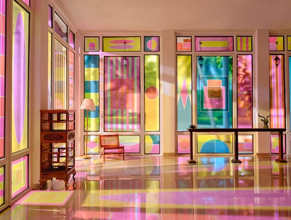 Room filled with colourful stained-glass windows creating vivid patterns on the floor - Beautiful Homes