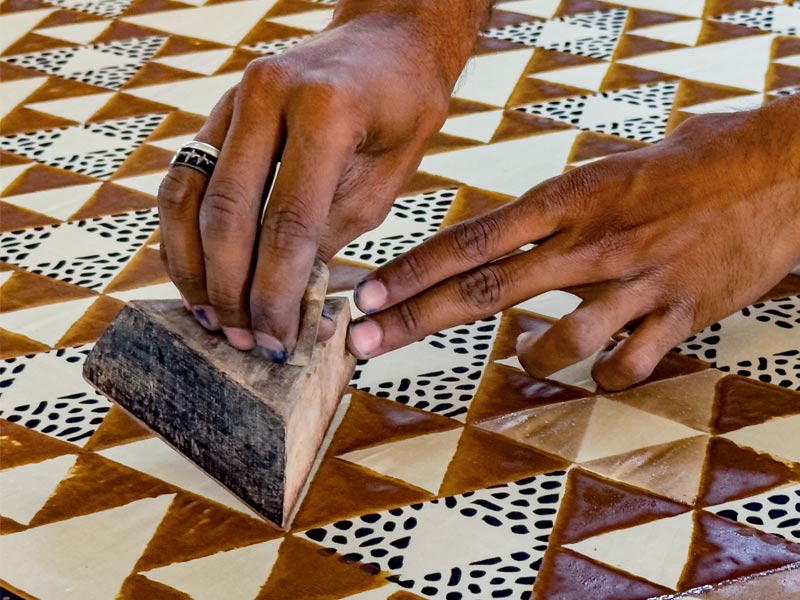 Hands using a wooden block for patterns on fabric – Beautiful Homes