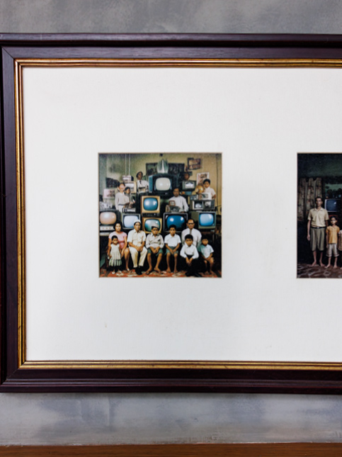 Framed vintage family photo with old TV sets on a textured grey wall – Beautiful Homes