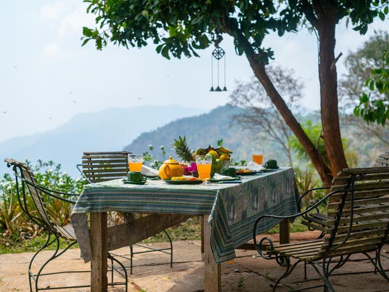 Outdoor Dining at Isla’s Ridge Under the Shade of a Tree - Beautiful Homes