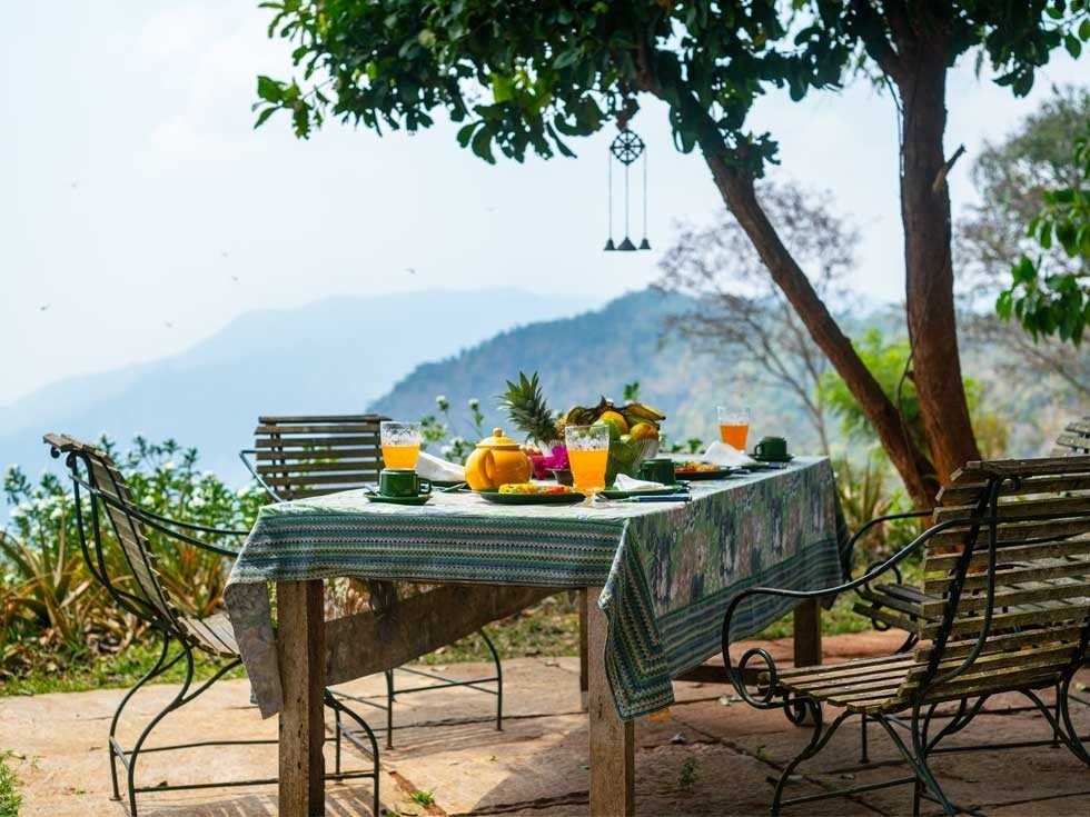 Outdoor Dining at Isla’s Ridge Under the Shade of a Tree - Beautiful Homes