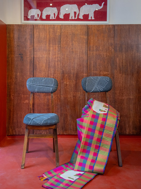 Two Wooden Chairs, One Draped with a Checkered Textile - Beautiful Homes
