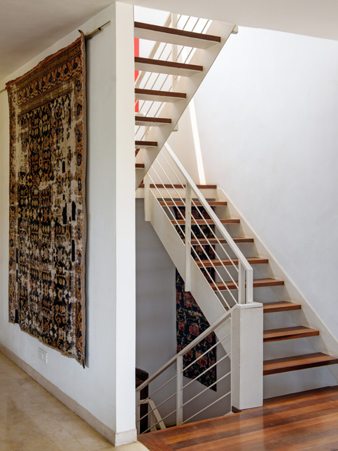 A decorative rug hangs beside a staircase - Beautiful Homes