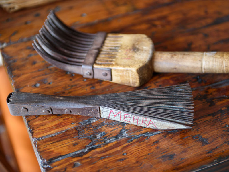 Two traditional weaving tools on a wooden surface - Beautiful Homes