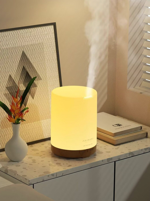 A softly lit ASAKUKI essential oil diffuser emits calming mist – Beautiful Homes