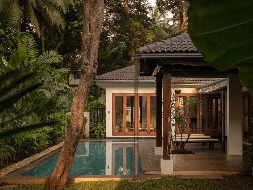A serene villa nestled in lush greenery features a private pool, wooden deck, and large glass doors – Beautiful Homes
