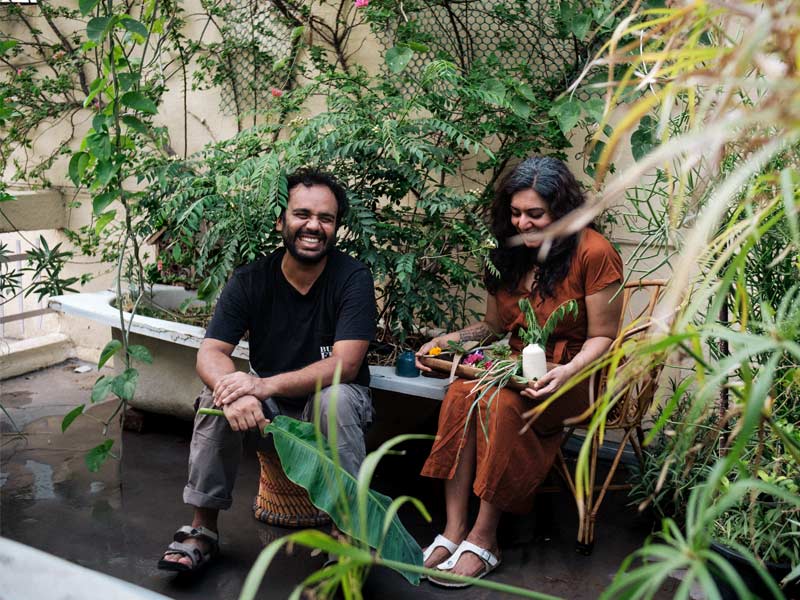 Kush and Meenakshi are seated outdoors amidst lush greenery - Beautiful Homes