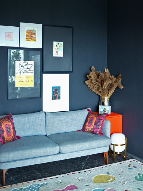 Devika Narain's study features dark walls softened by a gallery wall of art, vibrant cushions, and natural light – Beautiful Homes