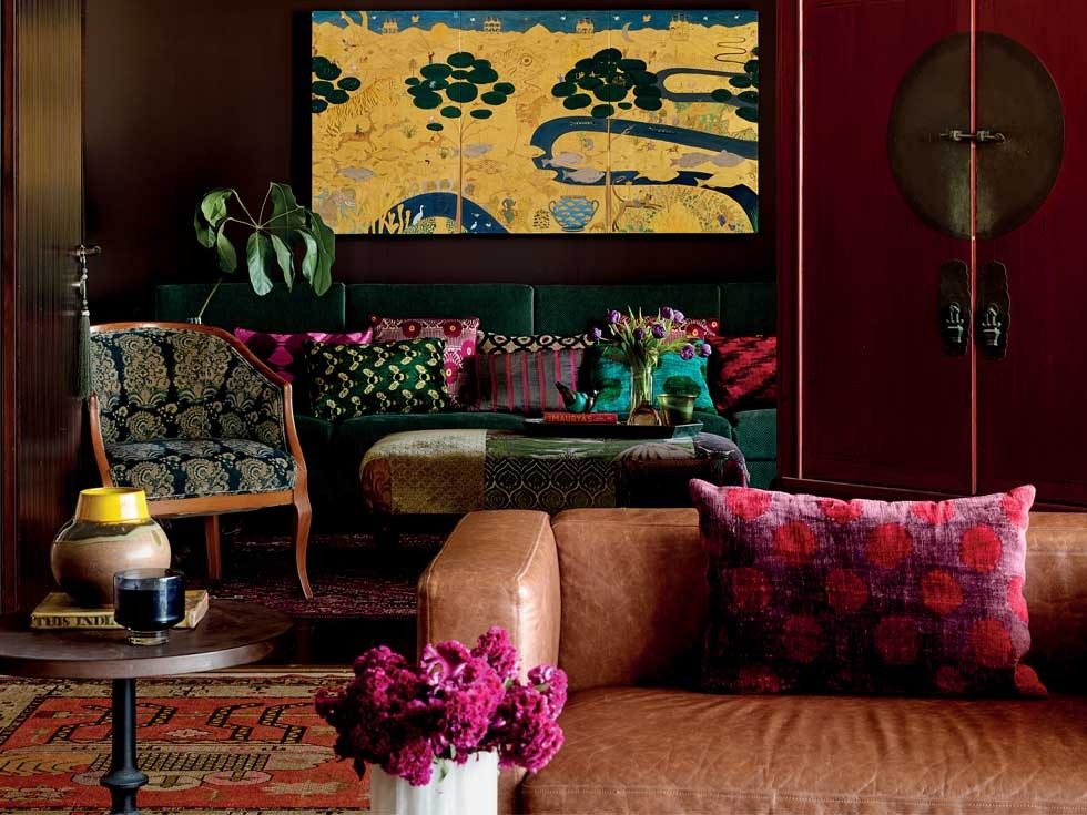 Pavitra's den, with Havana Cigar-toned walls, features a custom leather sofa, yellow artwork, and richly layered textiles – Beautiful Homes