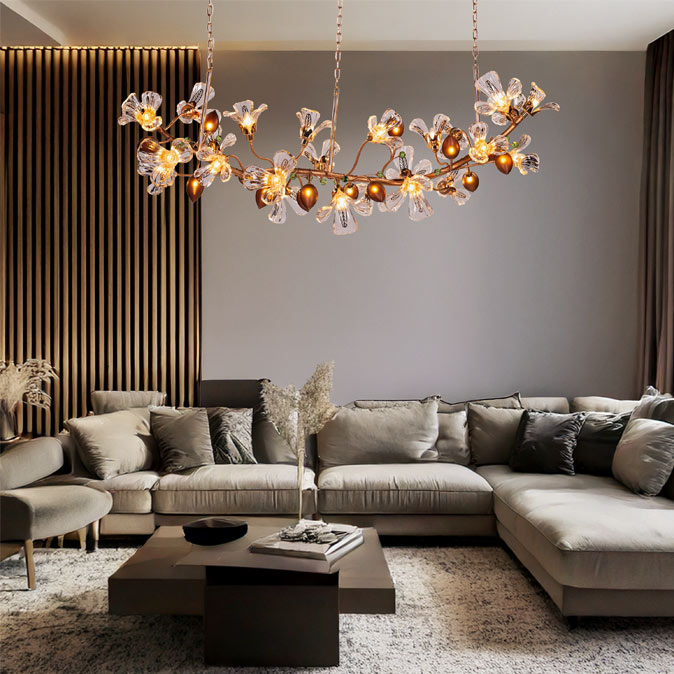 A large, ornate chandelier with crystal flowers and amber lights hangs above a modern living room with a sectional sofa and dark wood accents – Beautiful Homes