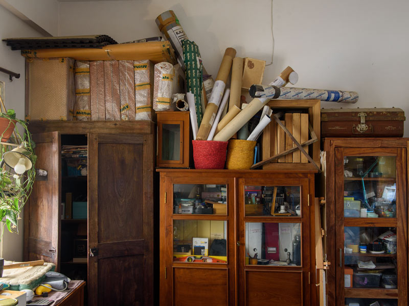 Cluttered Room with Wooden Cabinets, Rolled Papers, and Various Storage Items – Beautiful Homes