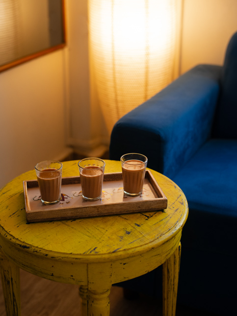 Three glasses of chai on a rustic yellow table in a cozy living room – Beautiful Homes
