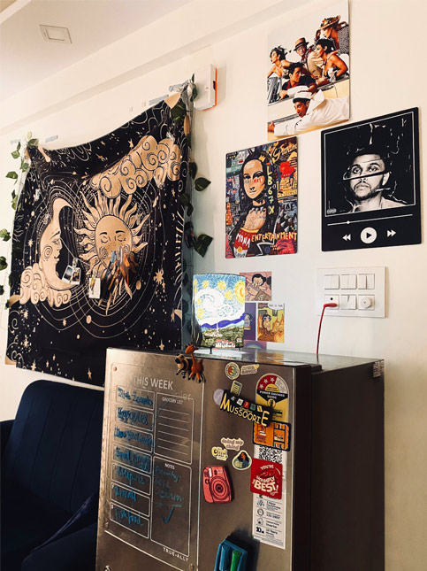 Eclectic wall décor with celestial tapestry, pop art posters, and a magnet-covered fridge – Beautiful Homes