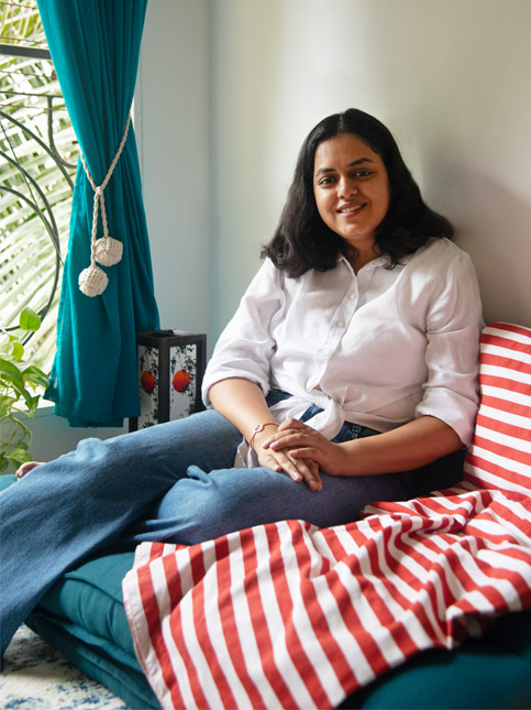 Relaxed modern living corner with a teal sofa, accented with a red striped throw and teal curtains – Beautiful Homes