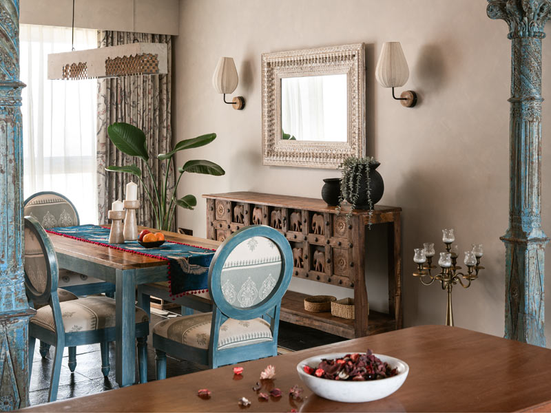 A wide-angle view of a dining room with a wooden table and blue chairs - Beautiful Homes