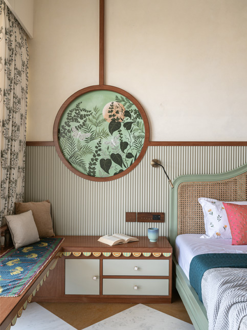 Master bedroom with a window seat, storage drawers, and round botanical artwork - Beautiful Homes
