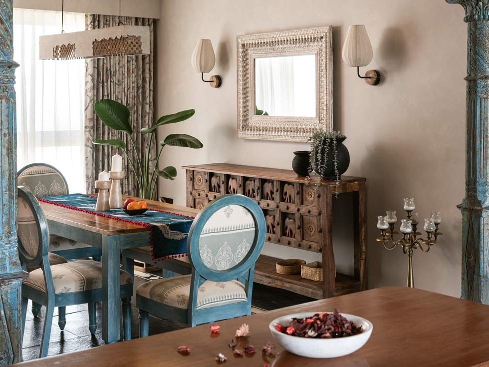 A wide-angle view of a dining room with a wooden table and blue chairs - Beautiful Homes
