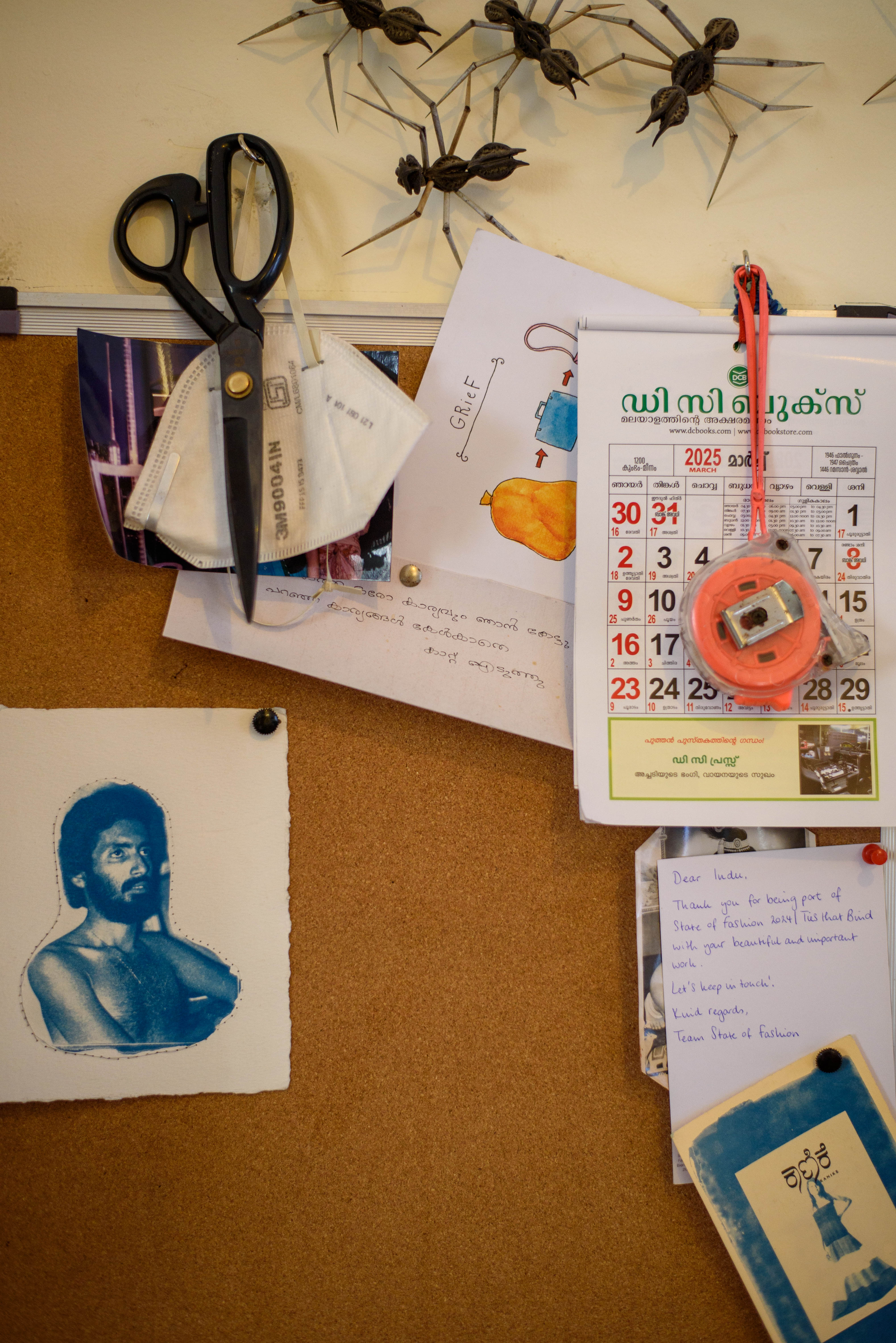 Creative bulletin board with scissors, calendar, artwork, and handwritten notes – Beautiful Homes