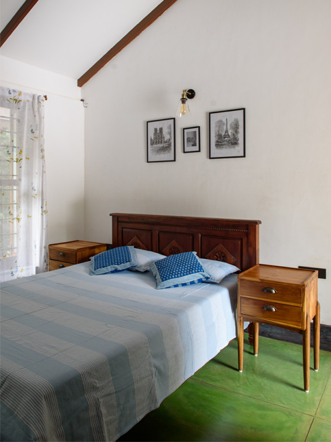A bedroom with a large wooden bed, two matching wooden nightstands, and blue and white striped bedding - Beautiful Homes