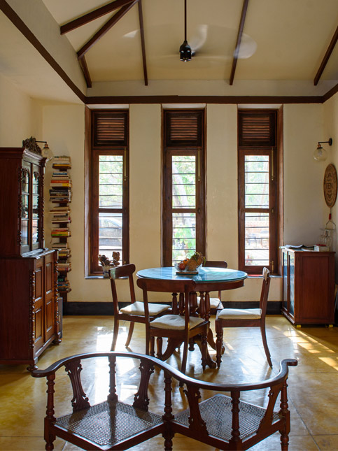 Interior view of a dining area with vintage wooden furniture, a display cabinet, and a high ceiling - Beautiful Homes