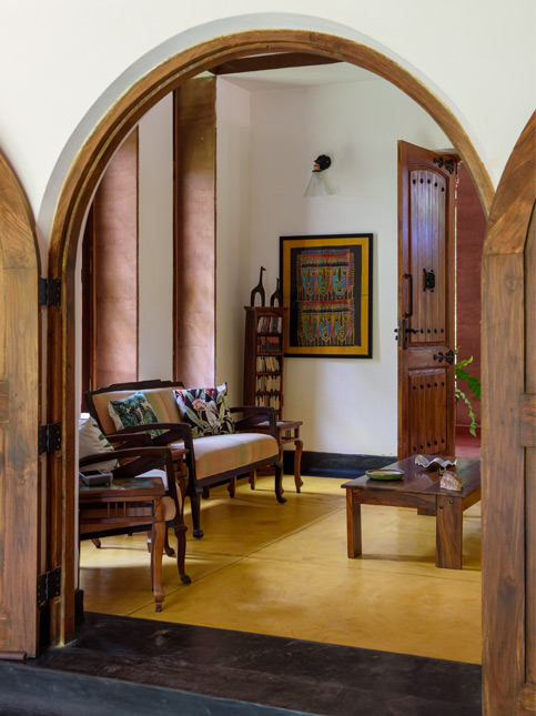 A living room featuring dark wooden furniture and a large, colourful framed painting on the wall - Beautiful Homes