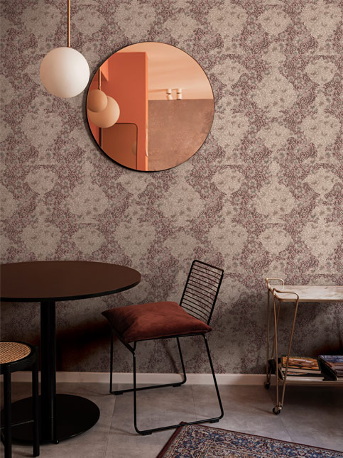 Flyaway Flowers wallpaper in a brown colourway, with a round mirror and a small dining set, creating a cozy and stylish interior – Beautiful Homes