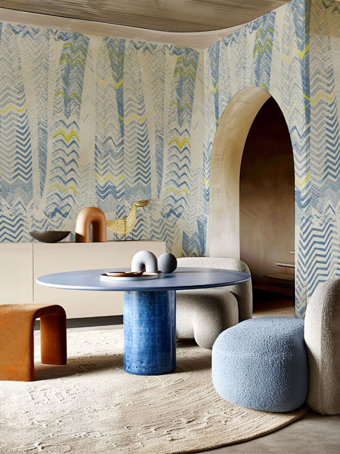 The Unfolding Story wallpaper in a blue colourway, adding an elegant backdrop to a dining area with a wooden table and chairs – Beautiful Homes