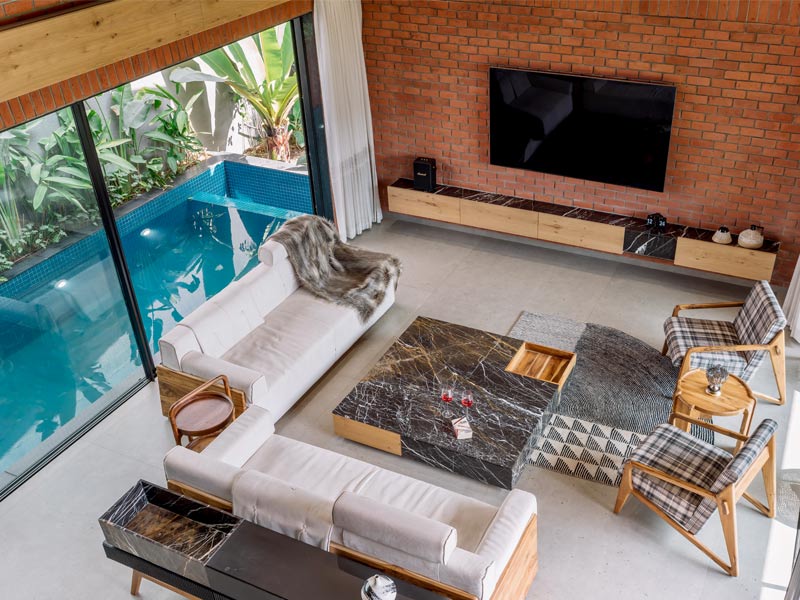 Large glass windows blurring indoor and outdoor spaces with views of garden and pool – Beautiful Homes